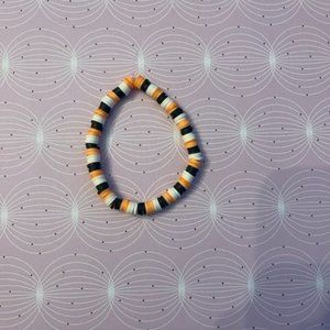 Black, orange, and white bracelet